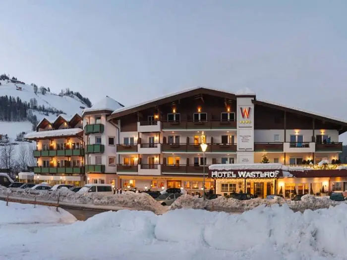 Hotel Wastlhof in de sneeuw bij avond, met verlichte gevel