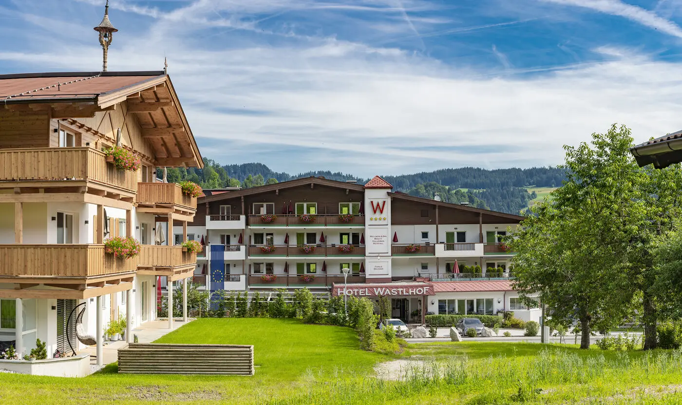 Hotel Wastlhof in de zomer, gezien vanuit een bloeiende bergweide